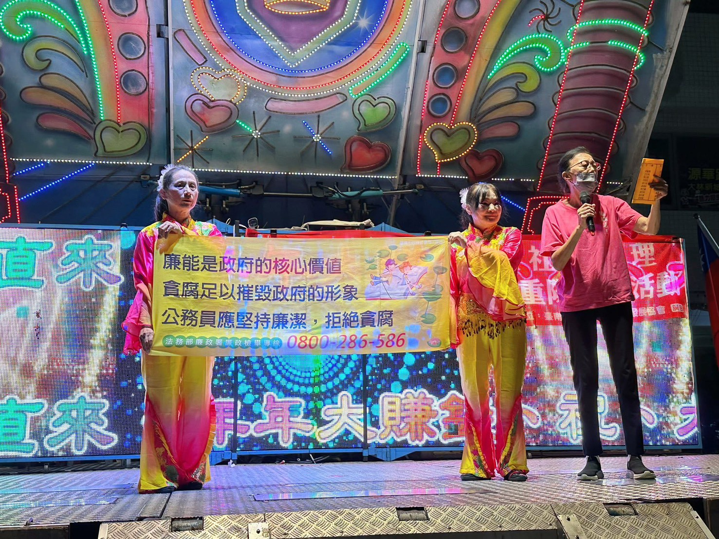 舞動廉潔力量-新生社區重陽節反貪宣導活動，臺南市政府政風處廉政志工以標語向民眾宣導反貪腐
