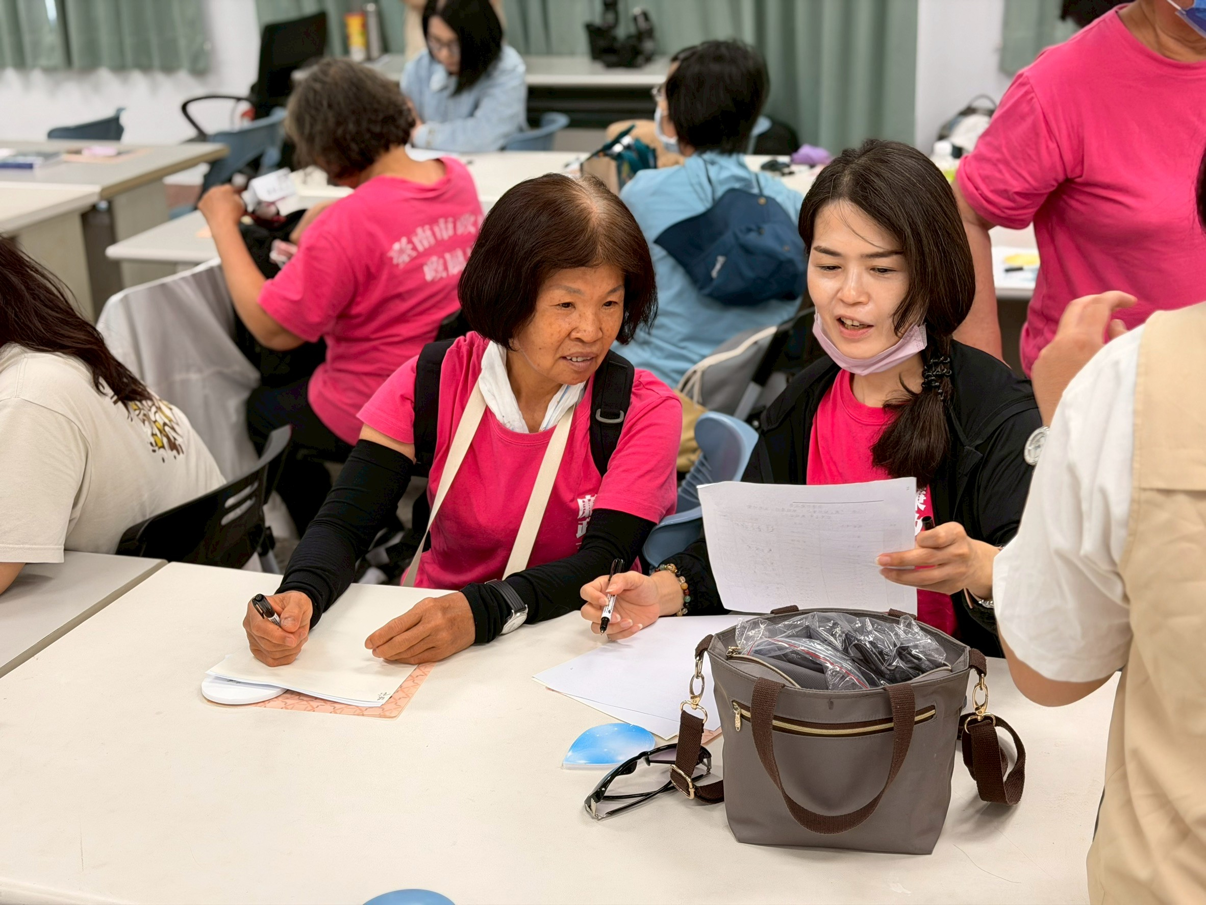 臺南市政府115年「『廉』結社會力·綠能透明」廉政志工交流研習廉政志工互相討論專題上課內容及做筆記。